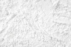 Flour close up background. A pile of flour on a white background. Spilled flour. Flour texture